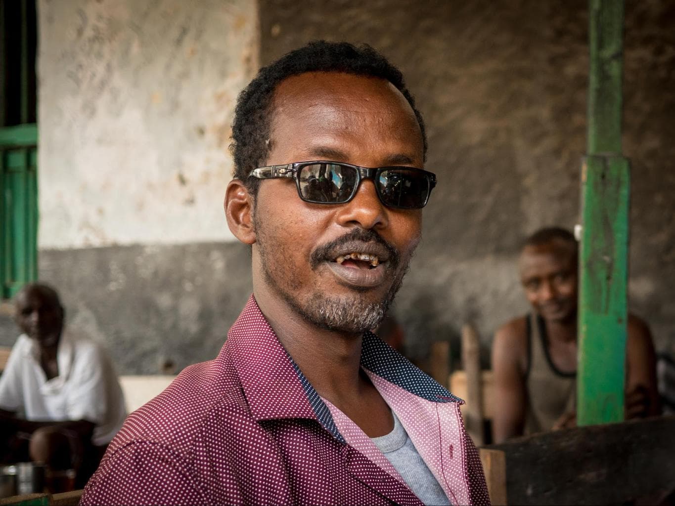 A curious local looking more like a kingpin, chatting us up at a coffee shop