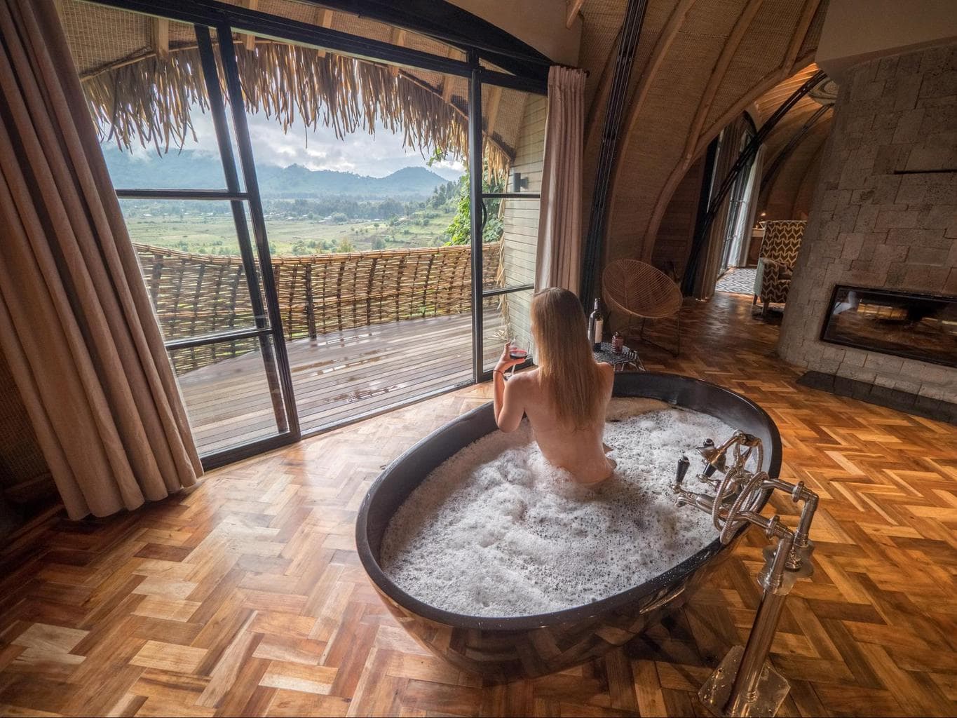 Soaking in the hot bathtub with a glass of wine while it’s cold outside at Bisate Lodge